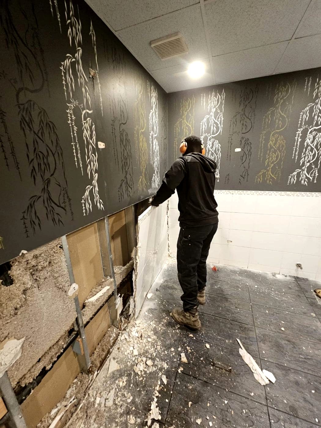 Zebra Demolition crew member stripping out a commercial wall