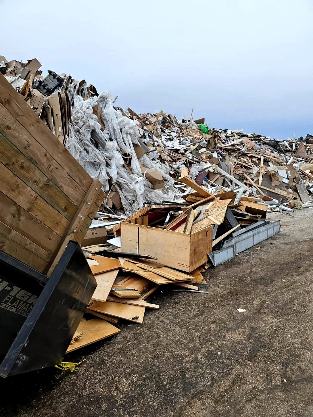 Structural demolition debris from a whole-building teardown loaded for haul-off