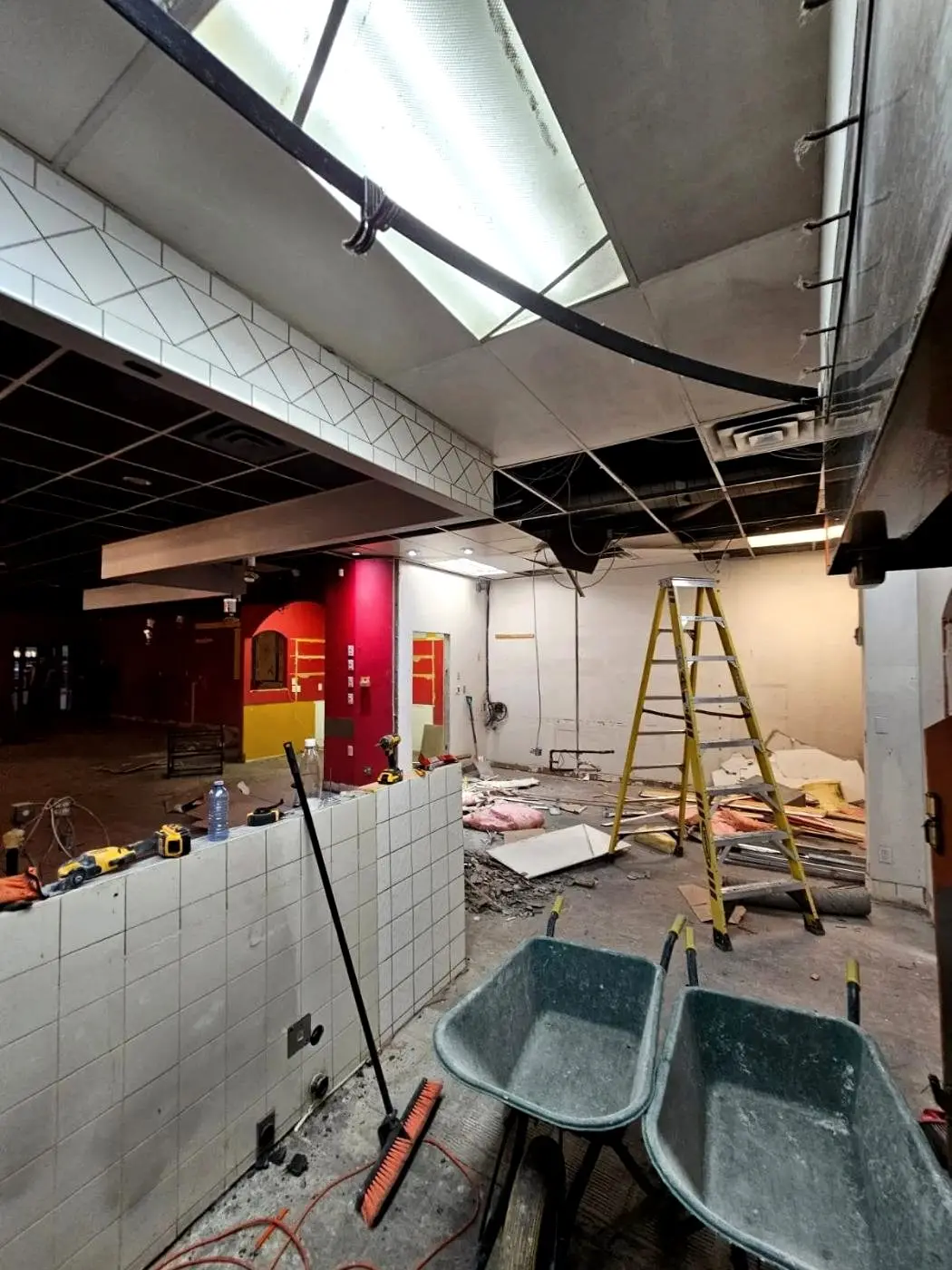 Commercial interior strip-out in Edmonton with the ceiling grid removed