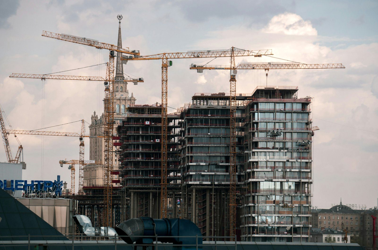 Mid-rise buildings under construction with tower cranes on a redevelopment site